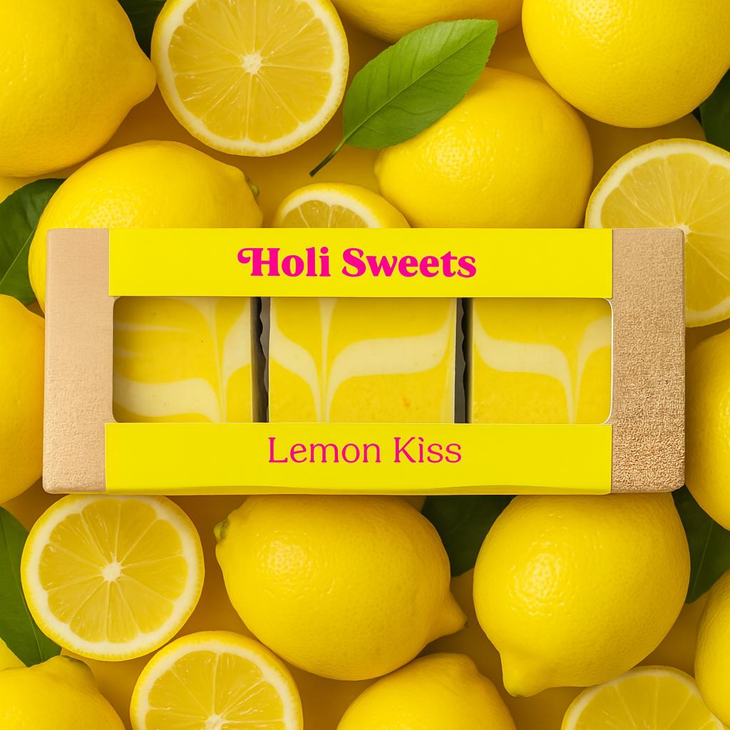 Holi Sweets Lemon Kiss vegane Dessertbox auf einem Hintergrund aus frischen ganzen und geschnittenen Zitronen – handgemachte pflanzliche Süßigkeit, glutenfrei, laktosefrei, sojafrei, ohne raffinierten Zucker, umweltfreundlich verpackt und hergestellt in München