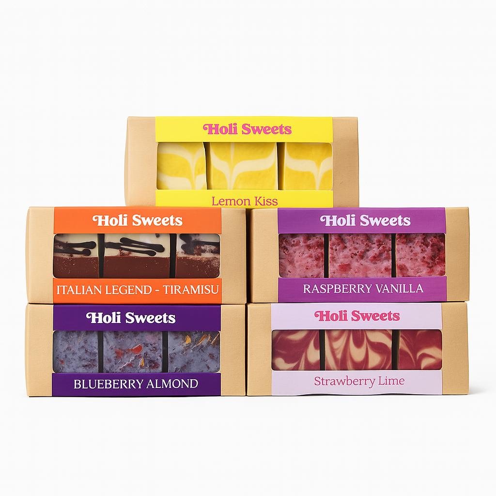 Fünf vegane Dessertboxen von Holi Sweets mit den Sorten Lemon Kiss, Italian Legend Tiramisu, Raspberry Vanilla, Blueberry Almond und Strawberry Lime – stilvoll arrangiert vor weißem Hintergrund. Handgemachte, pflanzliche Süßigkeiten, glutenfrei, zuckerfrei und ideal für eine bewusste Ernährung.