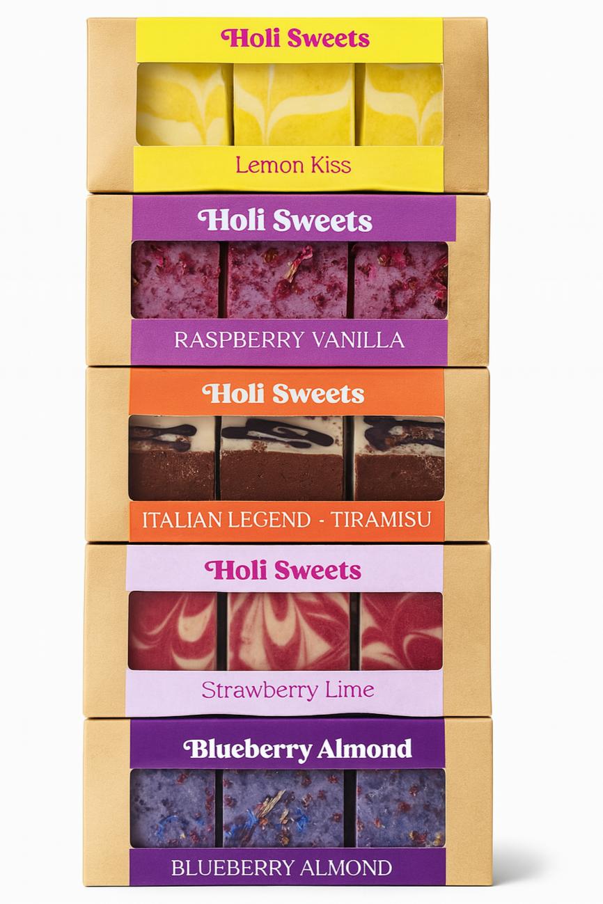 Fünf gestapelte Holi Sweets Boxen mit veganen Desserts in verschiedenen Geschmacksrichtungen wie Lemon Kiss, Raspberry Vanilla, Italian Legend Tiramisu, Strawberry Lime und Blueberry Almond auf weißem Hintergrund – gesunde, handgemachte, glutenfreie Süßigkeiten ohne Zucker aus München.