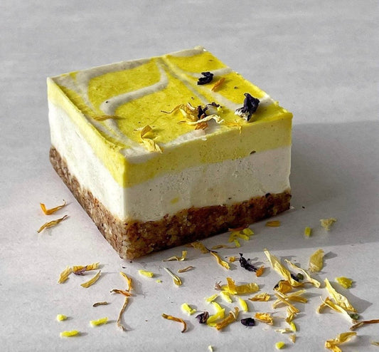 Rohveganer Zitronen-Kuchen mit Cashewcreme auf Nussboden, handgemachte süße Spezialität aus der raw patisserie München. Zuckerfrei, glutenfrei, vegan. Perfekt zum online Süßigkeiten bestellen in Deutschland und Österreich.